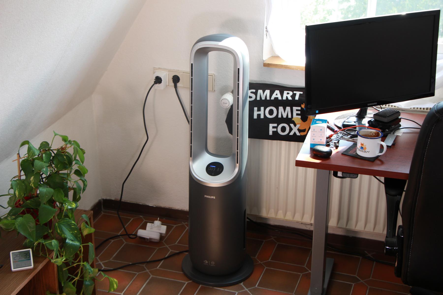 Der Philips Air Performer 8000 (AMF870/15) steht im Büro neben einem Schreibtisch und kann in diesem Bereich die Luft reinigen und beheizen.